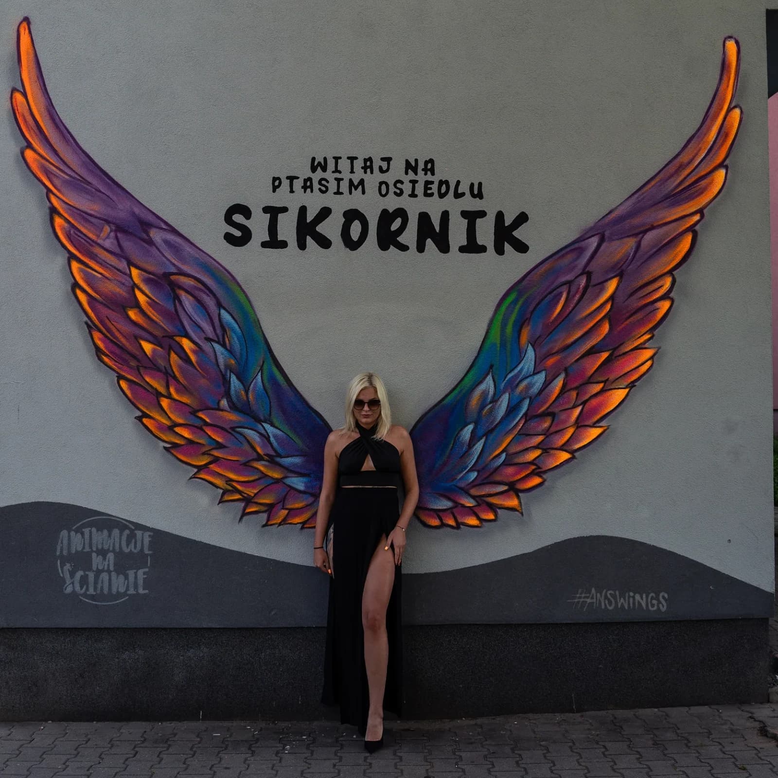Kolorowe skrzydła. Mural namalowany na ścianie, by stanąć przy nim i zrobić zdjęcie z imitacją skrzydeł na plecach