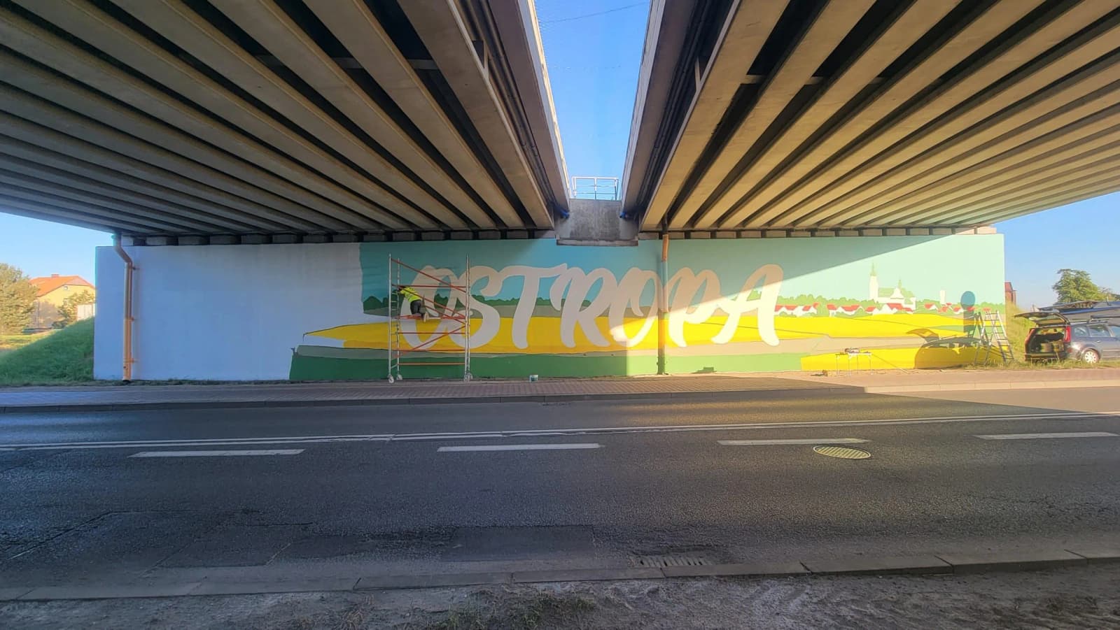 Wielkoformatowy mural Ostropa z panoramą dzielnicy pod wiaduktem